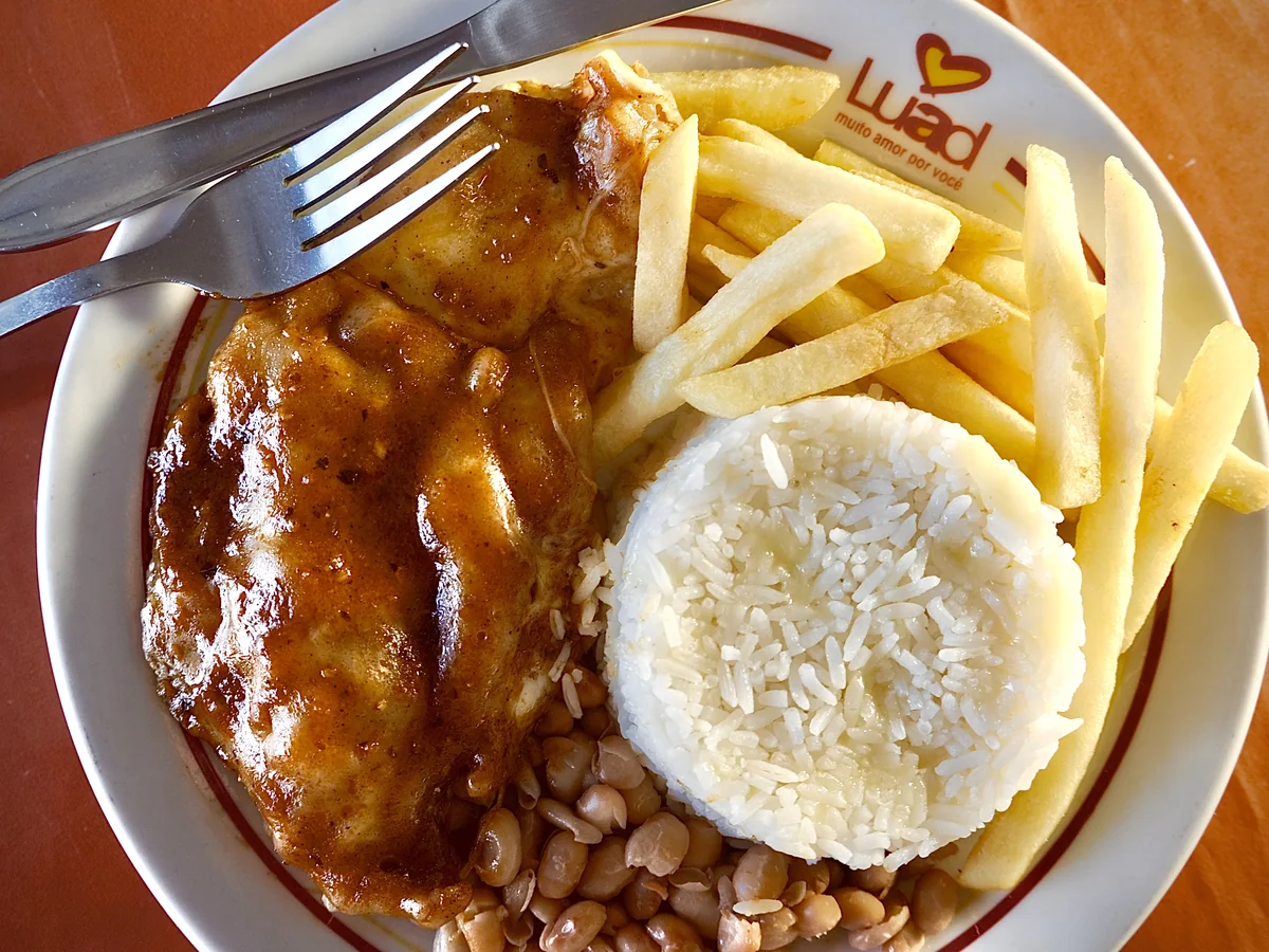 Prato servido com fritas, arroz, salada e legumes